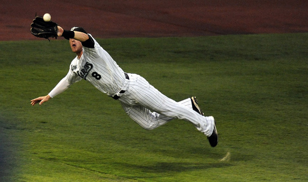 Florida Marlins out fielder Chris Coghlan (8) makes a diving catch against the Washington Nationals at Sun Life Stadium in Miami, Florida.