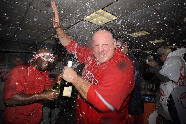 Los Angeles Angels center fielder Torii Hunter (L) sprays Los Angeles Angels Manager Mike Scioscia (R) as they celebrate in the club house after the Los Angeles Angels defeated the Boston Red Sox 7-6 to win the American League Division Series at Fenway Park in Boston, Massachusetts, USA 11 October 2009. 