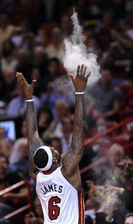 Miami Heat forward LeBron James tosses chalk in the air as part of his pre- game ritual against Cleveland Cavaliers at the American Airlines Arena in Miami, Florida