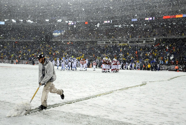 A stadium worker shovels the yard markers on the snow covered field during the New England Patriots against the Tennessee Titans game at Gillette Stadium in Foxborough, Massachusetts.