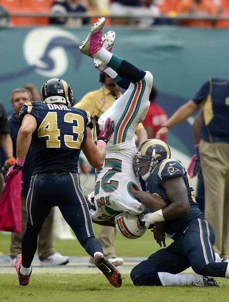 Miami Dolphins running back Reggie Bush (22) is upended during the second half of an NFL football game against the St. Louis Rams, Sunday, Oct. 14, 2012, in Miami. 