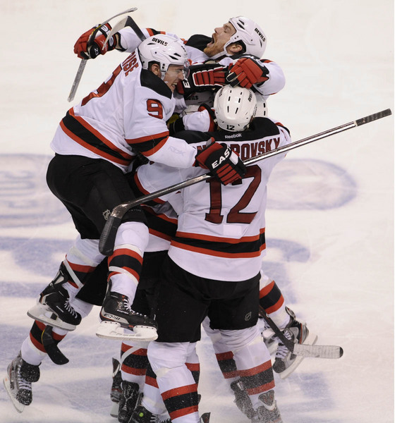 New Jersey Devils center Adam Henrique (14) is mobbed by teammates after scoring the game-winning goal against the Florida Panthers in double overtime during Game 7 of their NHL Eastern Conference quarter-final playoff hockey game in Sunrise, Florida April 26, 2012.