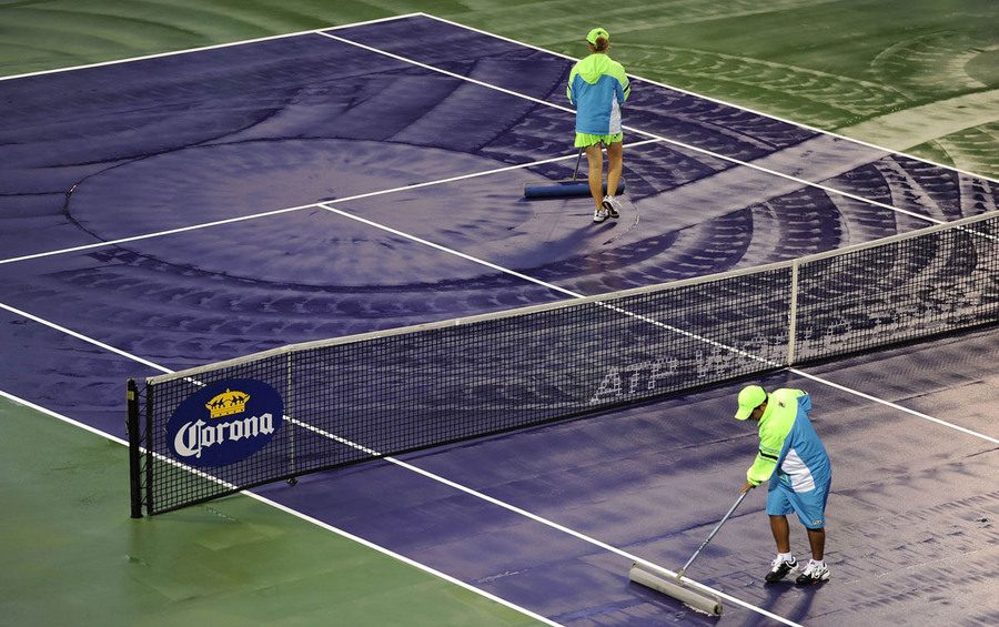 Stadium workers dry the court during a rain delay at the Sony Open tennis tournament in Miami, Florida, USA, 20 March 2013.