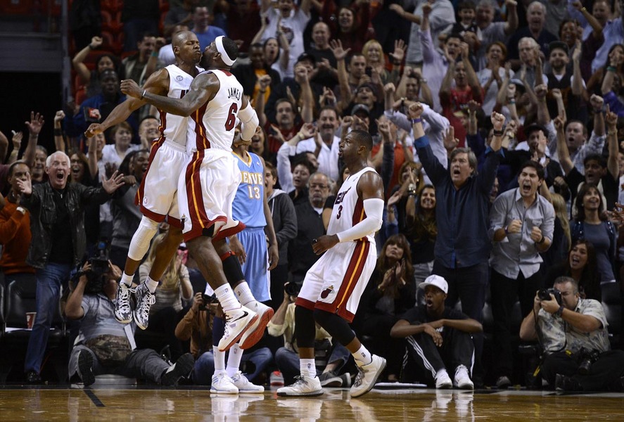 Miami Heat's (L-R) Ray Allen, LeBron James and Dwyane Wade celebrate in front of Denver Nuggets' Corey Brewer during the second half of their NBA basketball game in Miami, Florida, November 3, 2012.