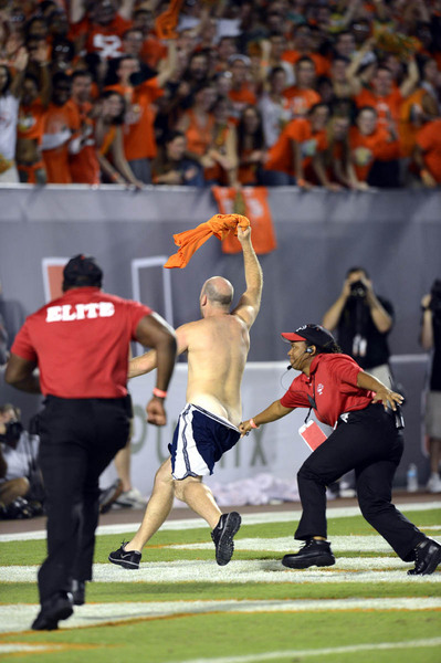 A fan is perused by an Elite Security Services member during the NCAA football game between the University of Miami Hurricanes and the Florida State University Seminoles at Sun Life Stadium in Miami, Florida.