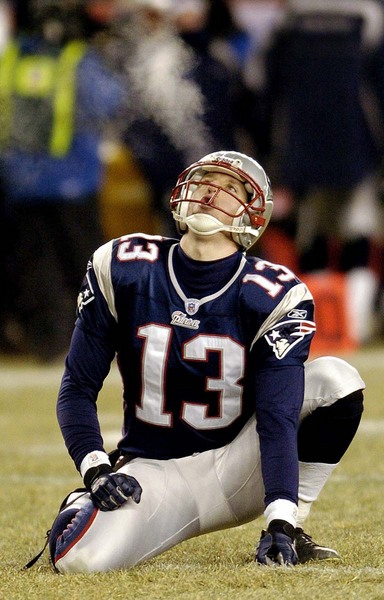 New England Patriots holder Ken Walter watches his breath as he blows into the air as he waits to hold for an Adam Vinatieri field goal attempt against the Tennessee Titans in the second quarter Saturday 10 January, 2004 at Gillette Stadium in Foxboro, Massachusetts.
