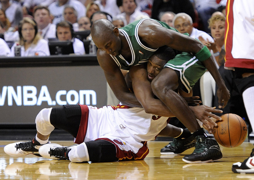 Boston Celtics center Kevin Garnett (R) and Miami Heat guard Dwyane Wade (L) fight for a loose ball during the second half of game seven of the Eastern Conference Finals at the American Airlines Arena in Miami, Florida