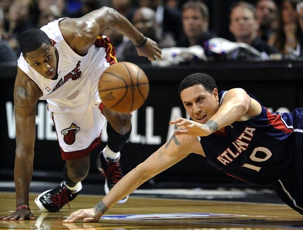 Miami Heat forward Mario Chalmers (L) Atlanta Hawks guard Mike Bibby (R) dive for a loose ball during game four of their first round Eastern Conference playoff game at the America Airlines Arena in Miami, Florida USA 27 April 2009. 