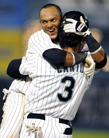 Florida Marlins Emillo Bonifacio (L) hugs teammate Jorge Cantu after scoring the winning run off Cantu's single in the ninth inning of their MLB National League game against the New York Mets in Miami, Florida  April 10, 2009.