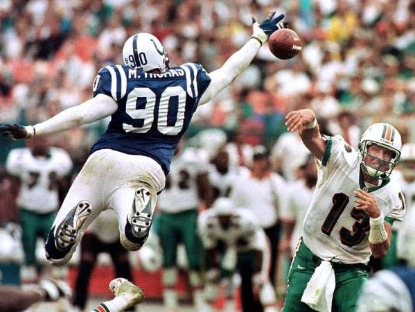 Indianapolis Colts defensive end Mark Thomas (L) bats down Miami Dolphins quarter back Dan Marino's (R) last pass of the game at Pro Player Stadium in Miami, Florida.
