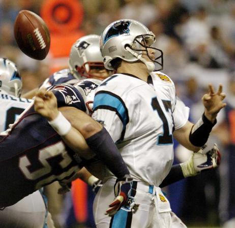 New England Patriots linebacker Mike Vrabek (L) hits Carolina Panthers quarterback Jake Delhomme forcing a fumble that set up a touchdown a few plays later in the second quarter of Super Bowl XXXVIII in Houston, Texas.