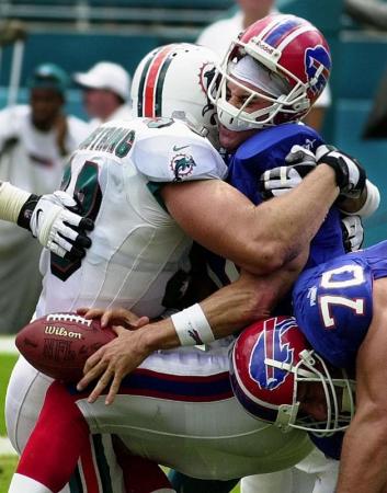 Buffalo Bills quarterback Rob Johnson's loses the ball as he is sacked by Miami Dolphins' defensive end Trace Armstrong  during the 2nd quarter of their game at Pro Player Stadium in Miami, Florida.