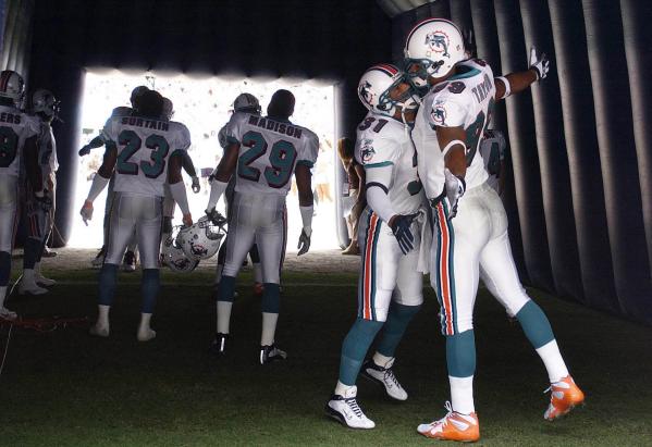 Miami Dolphins defensive backs Brock Marrion (L) and Jason Taylor (R) wait with othere team members to be announced to the crowd before their 2002-03 opener against the Detroit Lions at Pro Player Stadium In Miami, Florida.