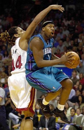 Charlotte Hornets Baron Davis (R) flies to the basket past Brian Grant of the Miami Heat during game 2 of their Eastern Conference play-off game against the Miami Heat at the American Airlines Arena in Miami, Florida.