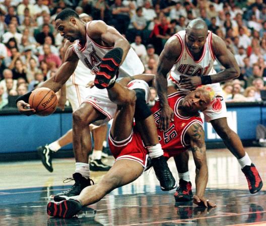 Miami Heat center Alonzo Mourning (L) and guard Tim Hardaway (R) scramble for a loose ball with Chicago Bulls forward Dennis Rodman during their playoff game at the Miami Arena in Miami, Florida.