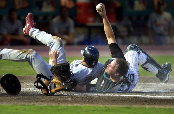 Florida Marlins catcher Mike Redmond (R) shows the ball to the umpire after he tags out Fernando Vina during their game at Pro Player Stadium in Miami, Florida.