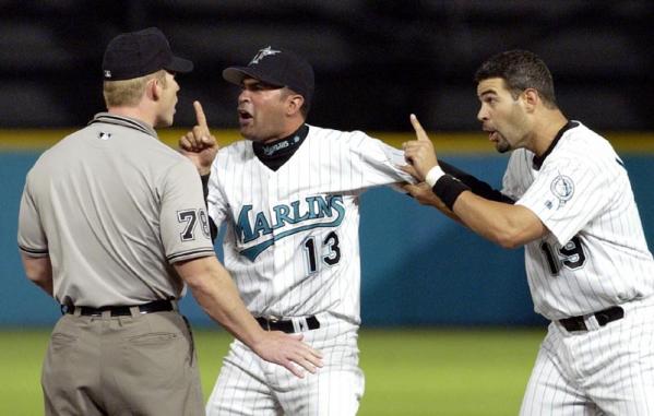 Florida Marlins 3rd base coach Ozzie Gullen (R) and Mike Lowell argue a call with an umprie during their season opener against the Montreal Expos at Pro Player Stadium in Miami, Florida.