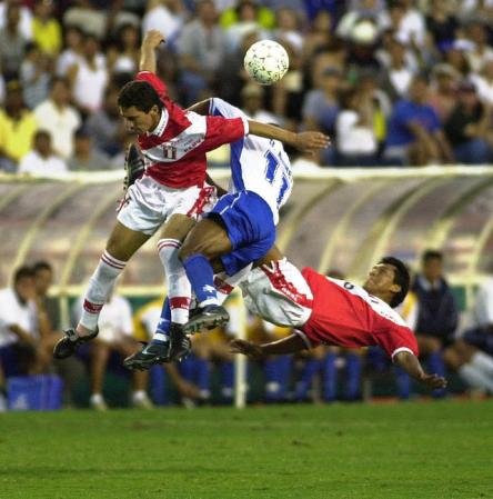 Jose Soto (L) and Cesar Rebosio (R) of Peru fight for a loose ball with Milton Nunez (C) of Honduras during the first half of their Gold Cup quarter-final match at the Orange Bowl in Miami, Florida.