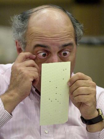 Broward County canvassing board member Judge Robert Rosenberg looks over a questionable ballot, 25 November 2000, at the Broward County Courthouse in Ft. Lauderdale, Florida. The Broward County canvassing board continues a manual recount of votes to make the 26 November deadline as mandated by the Florida State Supreme Court to accept hand-counted ballots for certification.