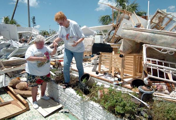 Lois Machukah (L) helps her friend Sally Shay (R) out of what once was her home in Punta Gorda, Florida, Sunday 15 August 2004. Charley, a category 4 hurricane with sustained winds of 145 miles per hour swept through the west coast of Florida 13 August leaving millions of dollars in damage in it's wake