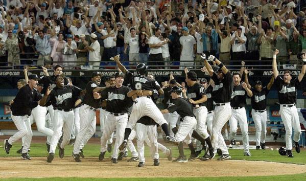 The Florida Marlins' bench erupts as Juan Pierre, picked up by Alex Gonzalez, scored the winning run in the bottom of the 11th inning against the San Francisco Giants during game 3 of the National League Division Series in Miami, Florida.