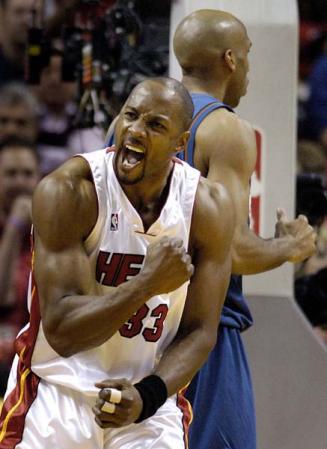 Miami Heat center Alonzo Mourning (Front) celebrates his shot and foul by Washington Wizards forward Michael Ruffin (Behind) during the second half of their eastern conference semifinal playoff game at the American Airlines Arena in Miami, Florida