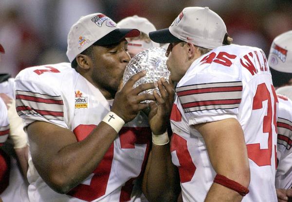 Ohio Buckeyes players kiss the Collegiate National Championship Trophy after defeating the Miami Hurricanes for the National Title at the Fiesta Bowl In Tempe, Arizona.