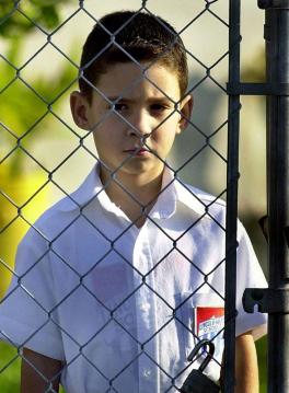 Six-year-old Elian Gonzalez opens the gate to leave for school at his Miami relative's home in Little Havana 08 March 2000. Gonzalez continues to be the center of a custody dispute between his natural father who lives in Cuba and his Miami relatives who want him to stay in the United States.